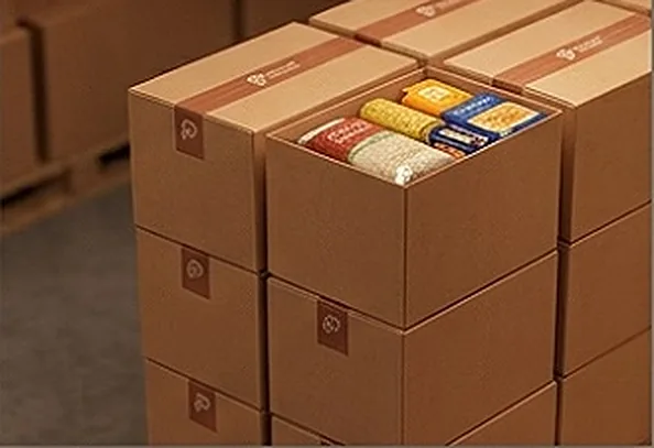 Cajas de alimentación embaladas y apiladas en el almacén de El Mercadito C.A.
